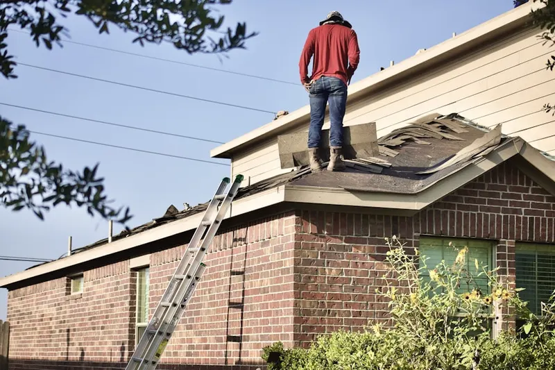 Professional roofer working on a residential roof in June Park